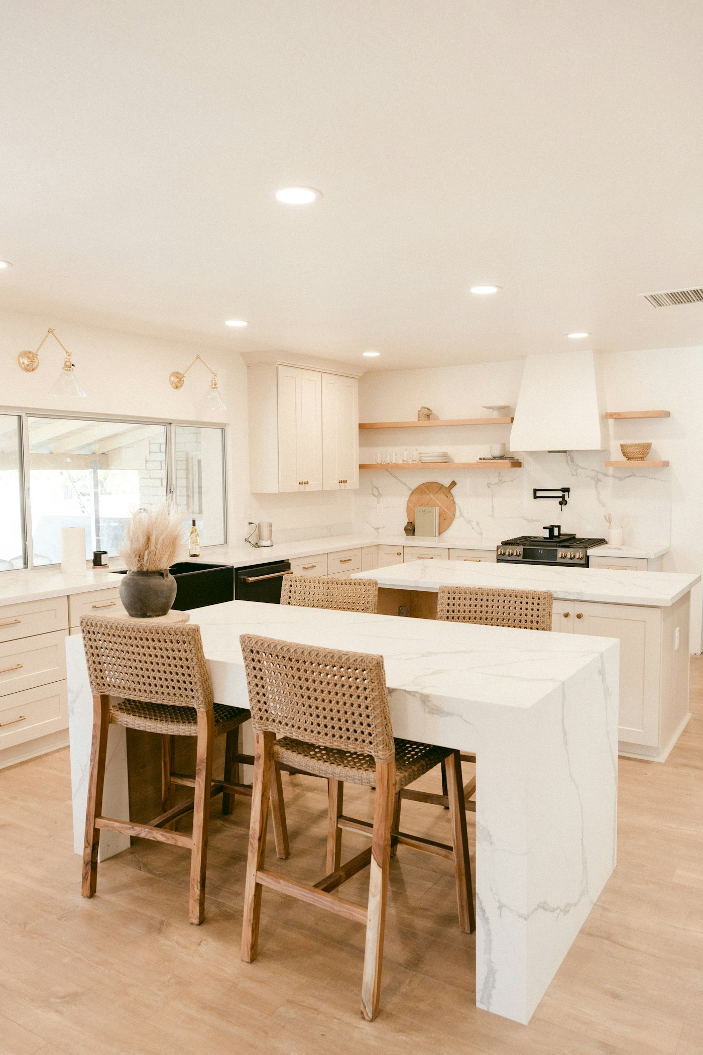 White marble kitchen island with woven bar stools